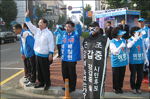 한나라당 진주시장 후보 공천에서 탈락한 강갑중 전 경남도의원의 한 지지자가 20일 오전 진주 중앙시장 앞 도로에서 열린 한나라당의 거리유세장에서 '근조' 복장을 하고 침묵시위를 벌이고 있다.