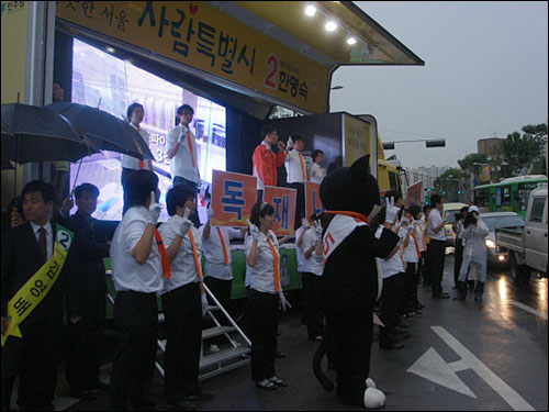 주황색 넥타이를 한 민주노동당 선거운동원들이 한 후보 유세장을 찾아 지지 유세전을 펼치고 있다. 