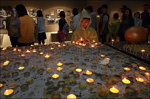 고 노무현 전 대통령 서거 1주기를 맞은 23일 오전 경남 김해시 봉하마을 노 전 대통령 묘역 앞에 마련된 '노무현 대통령 추모의 집'에서 한 어린이가 고인의 넋을 기리며 촛불에 불을 밝히고 있다.