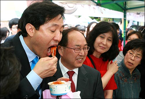 오세훈 한나라당 서울시장 후보가 23일 오전 서울 중구 명동성당에서 열린 미사에 참석한 뒤 바자회장을 방문하며 지지를 호소하던 중 떡볶이를 먹고 있다.