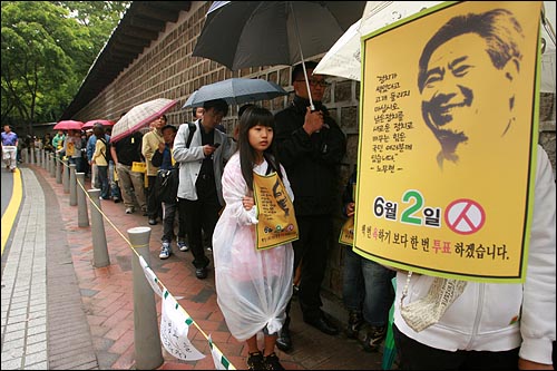  고 노무현 전 대통령 서거 1주기를 맞은 23일 오후 서울 덕수궁 대한문앞에 마련된 시민분향소에 헌화를 하기 위해 많은 시민들이 덕수궁 돌담길에 줄을 서 있다.