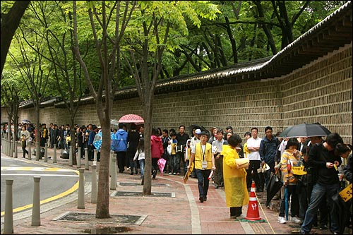 고 노무현 전 대통령 서거 1주기를 맞은 23일 오후 서울 덕수궁 대한문앞에 마련된 시민분향소에 헌화를 하기 위해 많은 시민들이 덕수궁 돌담길에 줄을 서 있다.