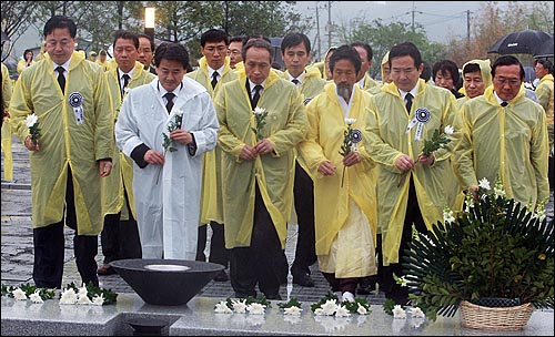  고 노무현 전 대통령 서거 1주기를 맞은 23일 오후 경남 김해시 봉하마을에서 정세균 민주당 대표와 강기갑 민주노동당 대표, 송영오 창조한국당 대표 등이 추모식을 마친 뒤 묘역을 찾아 헌화를 하고 있다. 사진왼쪽부터 김두관 무소속 경남도지사 후보, 정동영 민주당 의원, 이병완 광주 서구 구의회 의원 후보(전 청와대 비서실장), 강기갑 민주노동당  대표, 정세균 민주당 대표, 송영오 창조한국당 대표.