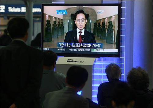 이명박 대통령이 24일 오전 서울 용산 전쟁기념관에서 천안함 사건 관련 대국민담화 발표를 하는 가운데, 서울역 대합실에서 시민들이 생중계방송을 지켜보고 있다.