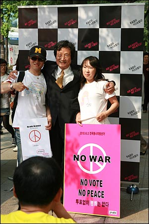 영화배우 문성근씨가 29일 오후 서울 마포구 홍대입구 지하철역 부근에서 열린 6.2지방선거 투표 참여 호소 'NO VOTE, NO KISS' 캠페인에서 투표참여 피켓을 들고 시민들과 기념촬영을 하고 있다.