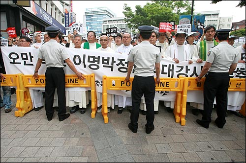 시국미사에 참석한 사제단과 신도들이 행진을 시작하자 경찰이 폴리스라인을 설치해 저지하고 있다.