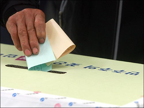 제5회 전국동시지방선거날인 2일 오전 서울 성북구 월곡 제1동 6투표소에서 '민주주의 꽃은 선거입니다'가 적혀있는 투표함에 지지하는 후보에게 기표한 투표용지를 넣고 있다. 