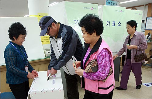 제5회 전국동시지방선거날인 2일 오전 서울 마포구 공덕동 주민센터에 마련된 제4투표소에서 유권자가 기표용지를 투표함에 넣고 있다.