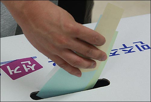 제5회 전국동시지방선거날인 2010년 6월 2일 오전 서울 마포구 공덕동 주민센터에 마련된 제4투표소에서 유권자가 기표용지를 투표함에 넣고 있다.