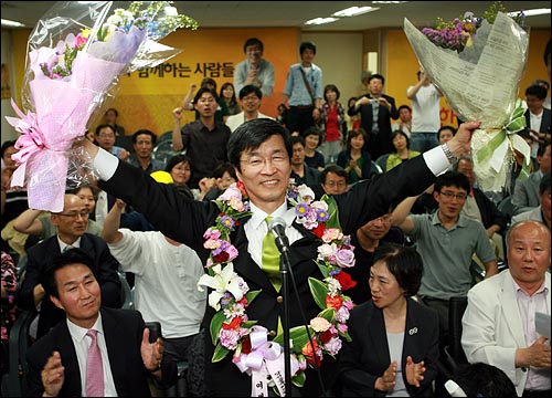 곽노현 서울시교육감 당선자가 6월 3일 새벽 서울 서대문구 선거사무실에서 지지자들이 선물한 꽃다발을 받아 들고 활짝 웃고 있다.