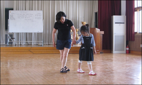 방과후 스포츠 댄스 시간에 연진이가 선생님의 자세를 따라해 보고 있다. 