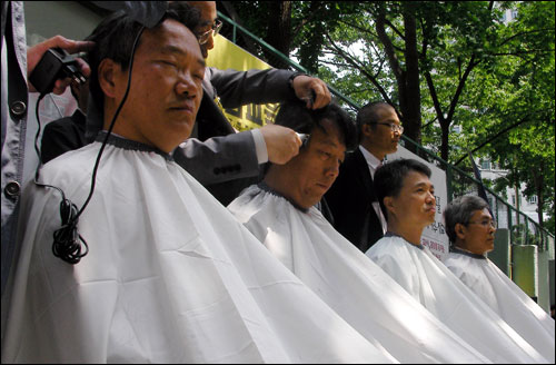 정대화(왼쪽) 등 상지대 교수 네 명이 지난 2010년 6월 사학비리 김문기 일가에 항의하며 서울 광화문 정부청사 후문에서 삭발을 하고 있다. 이들은 "비리재단의 상지대 복귀를 막기 위해 교과부가 나서라"고 요구했다.