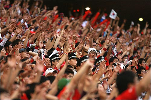  지난 5월 16일 오후 서울 상암월드컵경기장에서 열린 월드컵대표팀과 에콰도르의 평가전에서 축구팬들이 응원전을 펼치는 가운데, 경찰들이 붉은악마 응원단 사이에 서서 경기를 지켜보고 있다. 