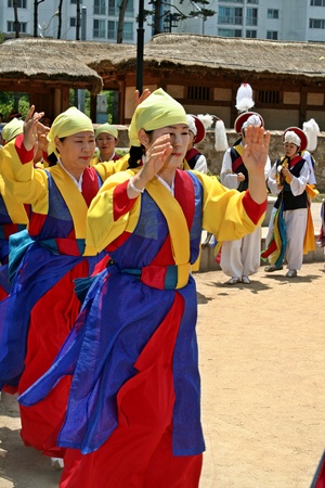 형형색색의 색동옷을 입은 아낙네들이 덩실덩실 풍물 장단에 맞춰 춤을 추고 있다.