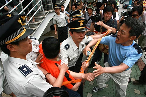 16일 오전 서울 종로구 참여연대 앞 시위에 참석한 보수단체 회원들이 건물 진입을 시도하며 경찰과 격렬한 몸싸움을 벌이고 있다.