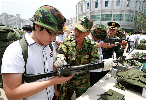 현역군인들이 학생들에게 소총 사용법을 교육하고 있다.