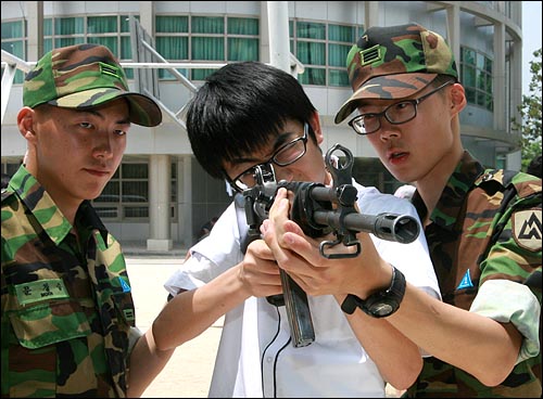 수도방위사령부 57사단이 실시하는 '6.25전쟁 60주년 현역지휘관 청소년 안보교육'이 2010년 6월 21일 오후 서울 성북구 삼선동 경동고등학교에서 열렸다. 학교 운동장에 군 장비가 전시된 가운데 현역군인들이 학생들에게 소총 사용법을 교육하고 있다.
