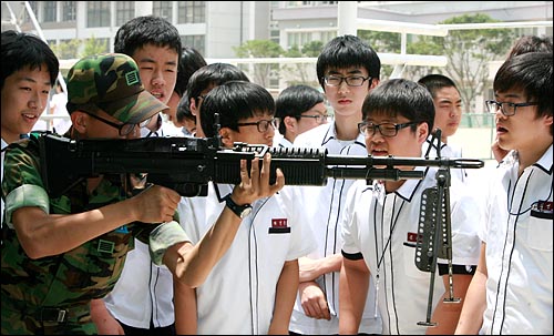 현역군인이 학생들에게 M60 기관총 사용법을 설명하고 있다.