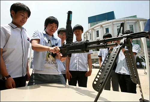 현역군인에게 M60기관총 사용법을 교육받은 학생이 직접 사격자세를 취하고 있다.