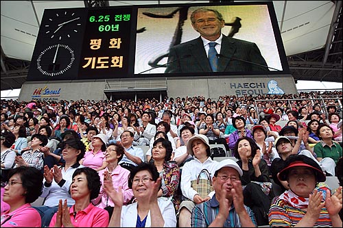  조지 W. 부시 전 미국 대통령이 22일 저녁 서울 상암동 서울월드컵경기장에서 열린 '분단을 넘어 평화로 6.25전쟁 60년 평화기도회'에서 평화메시지를 전달하자 참석한 기독교인들이 박수를 치고 있다.