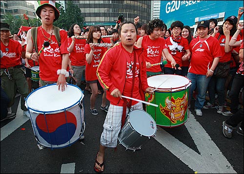  23일 새벽 서울광장에서 열린 한국과 나이지리아와의 거리응원에서 한국 대표팀이 나이지리아와 비기며 사상 월드컵 첫 원정 16강 진출이 확정되자 붉은악마들이 북을 두드리며 기쁨을 만끽하고 있다.