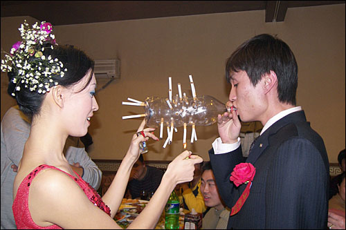 결혼식에서 흥을 돋우기 위해 담배 피우기 놀이를 하고 있는 신랑과 신부. 담배는 결혼식과 피로연에서 빠질 수 없는 필수품이다.