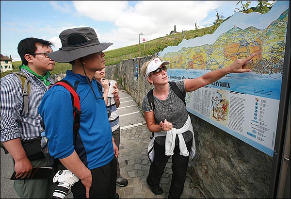 가이드 다그마(Dagmar)가 스위스 라보지구 포도밭 언덕에서 "이곳을 찾은 관광객들은 곳곳에 설치되어 있는 안내지도판을 이용해 편안하게 트래킹을 즐길 수 있다"며 취재팀에게 설명하고 있다.