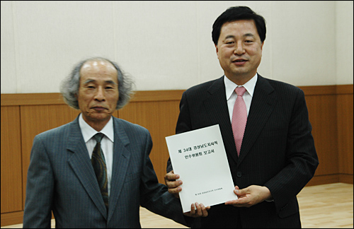  김두관 경상남도지사 당선인이 28일 오전 경남발전연구원 세미나실에서 열린 해단식에서 안승욱 인수위원장으로부터 보고서를 받은 뒤 포즈를 취하고 있다.