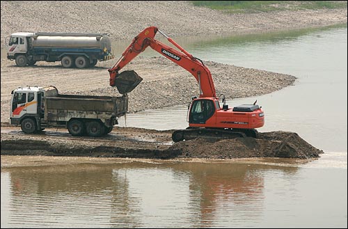 지난달 6일 오전 4대강 사업이 진행중인 경기도 여주 남한강변에서 굴착기가 강바닥 모래를 퍼내어 덤프트럭에 싣고 있다.