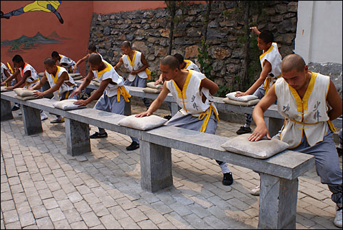 손바닥을 단련시키는 훈련하는 소림사 무승원의 승려들. 