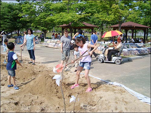 마을 축제 체험행사에서 어린이들이 흙과 함께 놀고 있다.