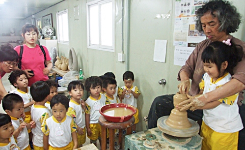 물레체험학습 고성에 있는 수로요.보천도예창조학교에서 이위준 교장이 어린이들에게 물레돌리기 체험을 시켜주고 있다.