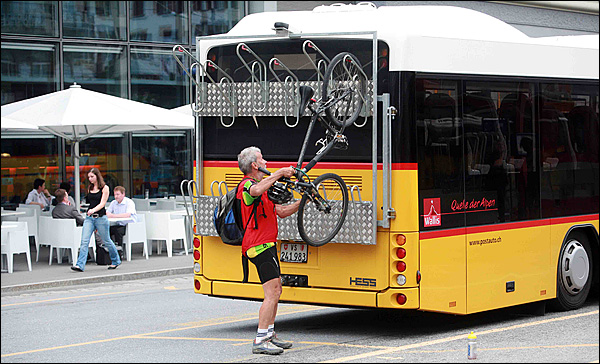 브리그역에서 본 우편버스(Postbus). 노란색 몸통에 호른 모양의 심볼마크가 그려져 있다. 승객은 물론 말그대로 우편물을 함께 운반하기 때문에 '우편버스'라는 이름이 붙었다.


