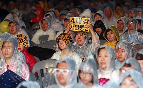 문수스님의 49재를 하루 앞둔 17일 저녁 서울광장에서 열린 '문수스님 소신공양 국민추모문화제'에서 시민들과 불자들이 4대강 사업 중단을 요구하며 손피켓을 들어보이고 있다.