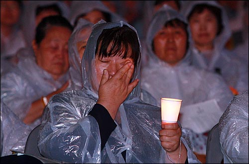 문수스님의 49재를 하루 앞둔 17일 저녁 서울광장에서 열린 '문수스님 소신공양 국민추모문화제'에서 한 시민이 추모영상을 보며 눈물을 닦고 있다.