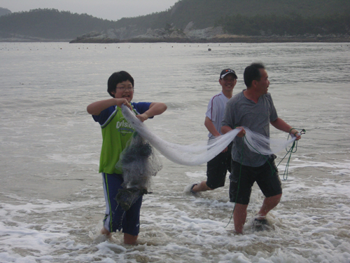 캠프 참가자들이 그물로 물고기를 잡는 장면
