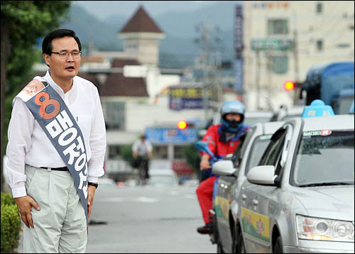 충북 충주 국회의원 보궐선거에 출마한 무소속 맹정섭 후보가 23일 법원로터리를 지나는 차량 운전자를 향해 선거운동을 하고 있다.
