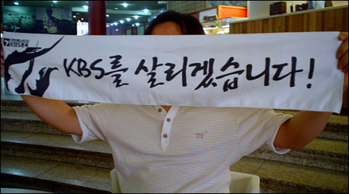 이번 투쟁의 슬로건이 찍힌 수건을 펼치는 KBS 새 노조 김우진 홍보국장 