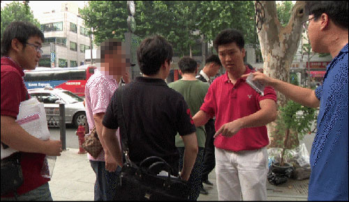 두산중공업 직원(까만 옷을 입고 등진 사람)이 노영수씨(오른쪽에서 두번째 빨간 옷) 등으로부터 사찰과 관련 항의를 받고 있다.