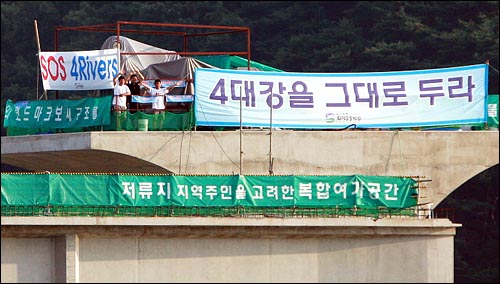  25일 오후 4대강 사업 중단을 촉구하며 경기도 여주 남한강 이포보 공사현장에서 4일째 점거농성중인 염형철 서울환경운동연합 사무처장, 장동빈 수원환경운동연합 사무국장, 박평수 고양환경연합 집행위원장이 지지방문한 사람들을 향해 손을 흔들고 있다.