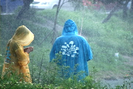 비가 내리는 동안에도 비옷을 입은 채 낚시를 하고 있는 대회 참가자들. 