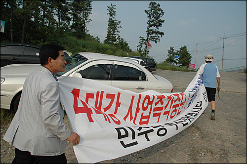 김덕영 부산 사상구의회 의장이 31일 오후 함안보 '농성 지원 상황실'을 찾아 펼침막을 걸기 위해 걸어가고 있다.