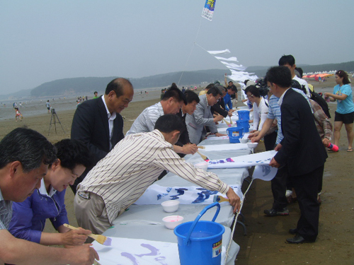 내빈들의 깃발전 참여 김세호 태안군수(가운데 안경 쓴 이)를 비롯한 내빈들이 몽산포 하늘에 띄울 깃발들에 그림과 글씨를 새기고 있다. 