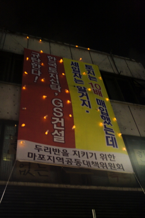 두리반 단전에 항의하는 네티즌들이 보내준 촛불이 두리반 외벽에 빛나고 있다.