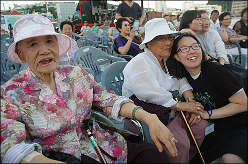 여고생들이 5일 오후 통영 강구안문화마당에서 열린 '일본군위안부 피해자 기금마련 평화인권문화제'에 참석할 할머니들과 사진을 찍고 있다.