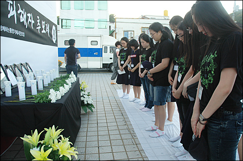 충렬여고와 통영여고 여학생들이 5일 오후 통영 강구안문화마당에서 열린 '평화인권문화제' 때 고인이 된 위안부 피해 할머니들의 영정 앞에 헌화한 뒤 묵념하고 있다.