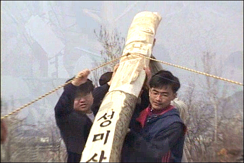 주민들은 서울시가 잘라낸 성미산의 나무를 며칠 동안 조각하여, 성미산대장군과 성미산여장군으로 부활시켰다. (김성환 감독의 다큐멘터리 <우리 산이야> 캡처)