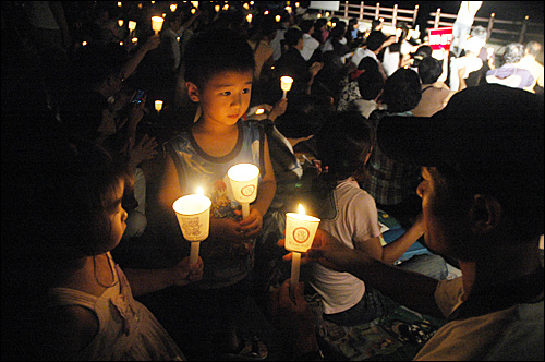 환경연합 두 활동가가 함안보 공사장 철탑에서 고공농성을 한 지 17일째인 7일 저녁 합안보 홍보관 옆에서 촛불문화제가 열렸다.