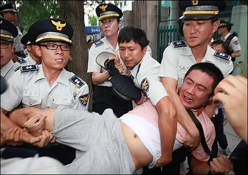 경찰들이 김문기 비리재단 복귀를 반대하며 농성을 벌이는 상지대 학생의 사지를 들어 강제연행하고 있다.