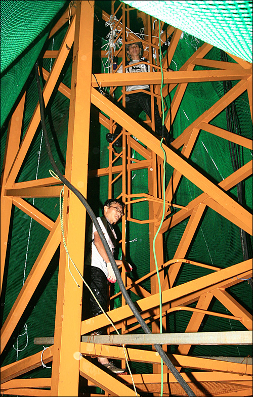  20일 동안 함안보 공사장 타워크레인에서 고공농성을 벌인 환경연합의 두 활동가가 10일 저녁 태풍이 닥친 속에 철탑을 내려오고 있다.